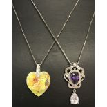 A decorative drop style pendant set with purple and clear stones on an 18" silver box chain.