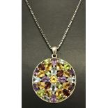 A modern design circular pendant set with multiple blue topaz, garnet, amethyst and citrine stones.