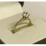 A 9ct gold solitaire dress ring set with round cut central clear stone.