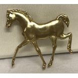 A 9ct gold brooch in the shape of a horse by Tonie Taylor for Ivan Tarratt.