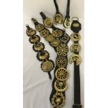 A collection of vintage horse brasses mounted on leather straps.