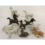 A collection of 12 small ceramic horse figurines.