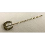 A decorative horseshoe stick pin. Tests as 9ct.