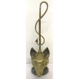 A vintage brass weighted door stop in the shape of a fox head.