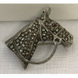 A vintage silver and marcasite brooch in the shape of a horses head with bridle.