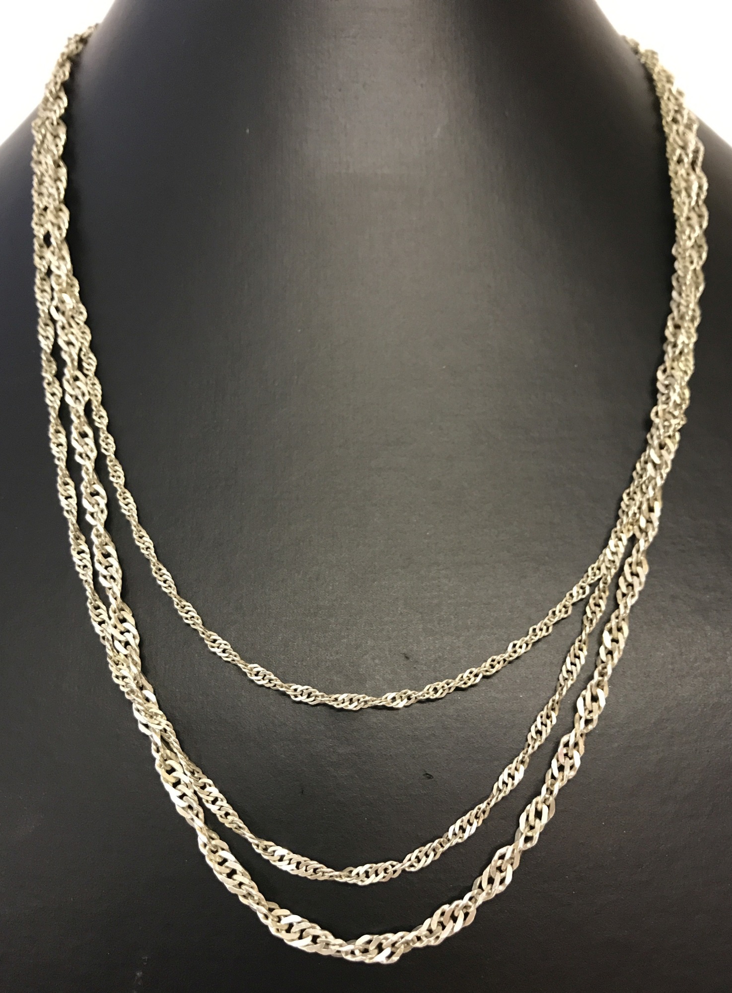 A graduating strand silver rope chain necklace.