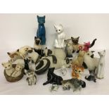 A collection of ceramic cats in a variety of sizes.