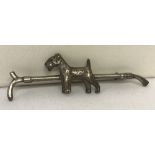 A vintage silver brooch in the shape of a riding crop with Airedale terrier decoration.