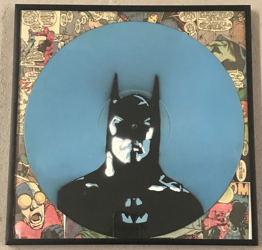 A framed and glazed vinyl record painted with Batman design.