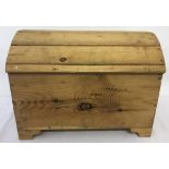 A large wooden toy box with curved lid and shaped feet.