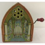 A vintage lithographed tin, hand cranked, mechanical Church organ music box.