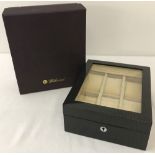 A new boxed Walwood glass-topped lockable watch box.