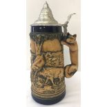 A large ceramic lidded stein with animal scene and fox shaped handle.
