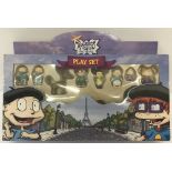 A boxed 2000 "Rugrats in Paris, The Movie" play set with figures, board and cardboard scenes.