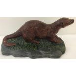 A painted cast iron doorstop in the shape of an otter.