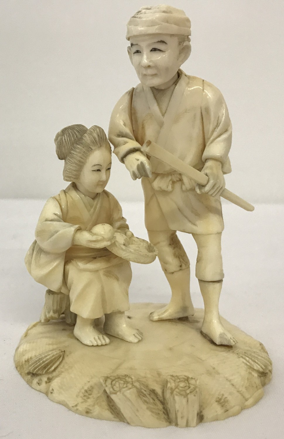 An antique carved ivory figure of an oriental lady and gentleman.