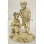 An antique carved ivory figure of an oriental lady and gentleman.
