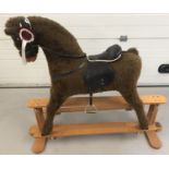 A Mamas & Papas glider rocking horse with leather effect saddle and reigns.
