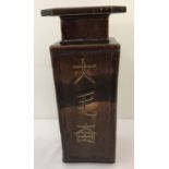 A Chinese brown glaze 4 footed square shaped vase. Chinese script to each side.