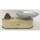 A vintage set of cream kitchen scales by Harper complete with weights.