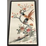 A framed and glazed embroidered silk panel of oriental pheasants in a tree.