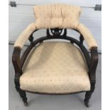 A Victorian curve backed nursing chair with turned legs and ceramic castor feet.