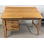 A vintage light wood 3 drawer artists desk with adjustable top.