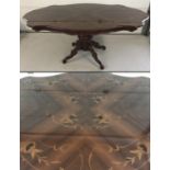 A French reproduction dining table with floral inlaid detail to top and highly polished finish.