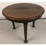 A vintage dark wood circular side table on 3 cabriole style legs.