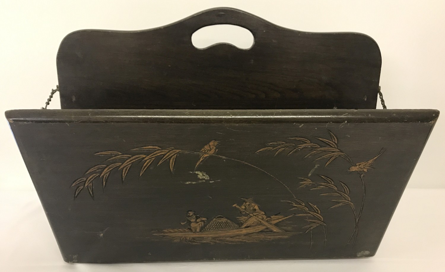 A vintage Chinese wooden magazine rack with carved detail to each side.