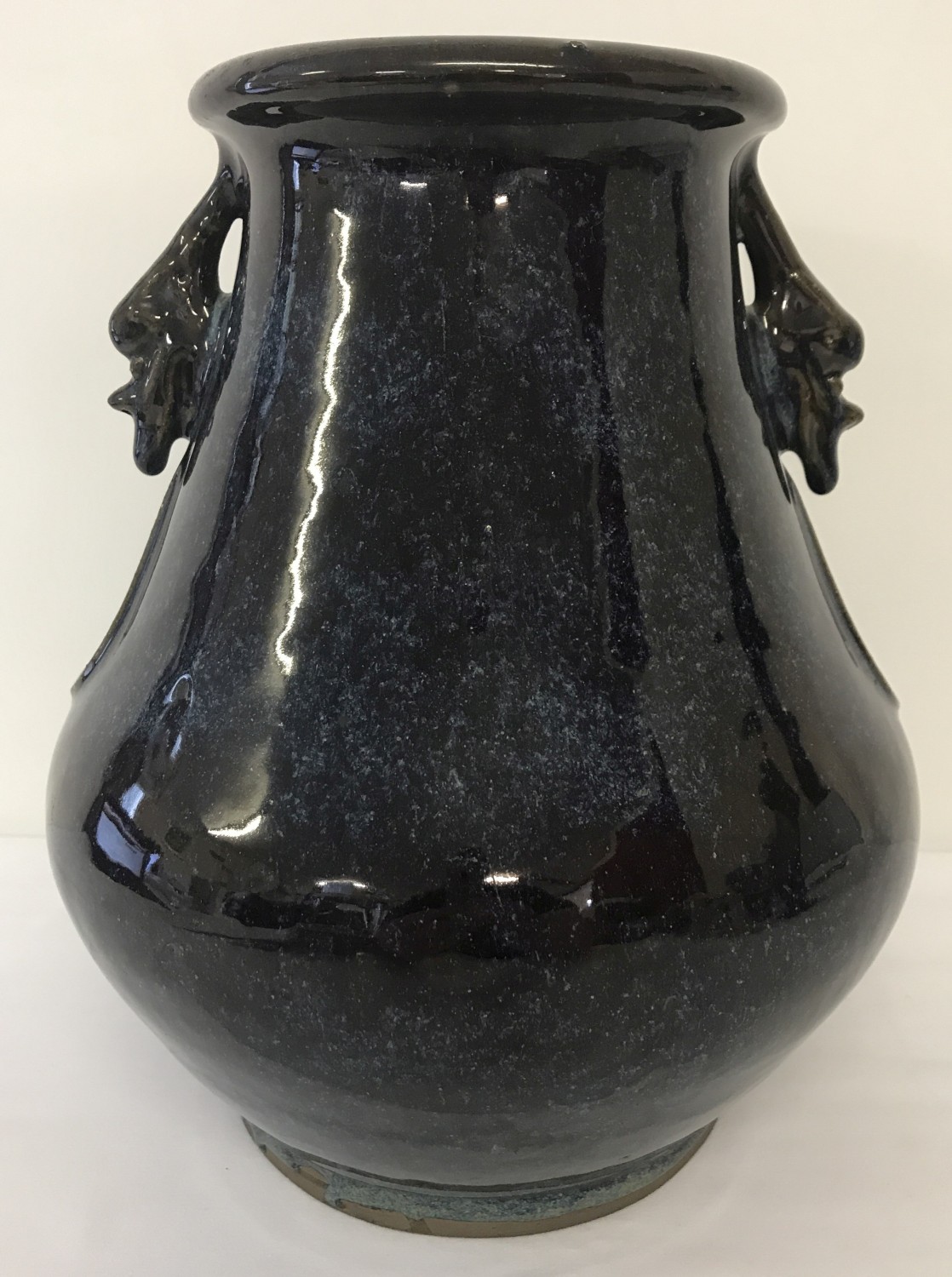 A Chinese blue flambé glaze bulbous shaped vase with stylised head decoration.