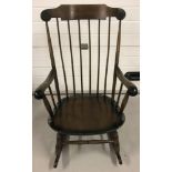 A vintage dark wood, spindle backed rocking chair.