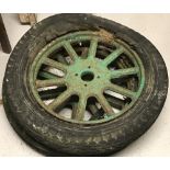 A pair of vintage painted spoked iron wheels with tyres possibly from a carriage.