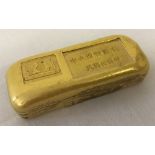 A Chinese gold coloured ingot with symbols and markings to top.