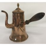 A Georgian copper chocolate pot with hinged lid, brass finial and original wood handle.