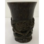 A carved horn Chinese Libation cup with floral detail to base and outer bowl.