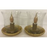 A pair of vintage table lamps; clear glass shades sat on wooden bases, painted gold.