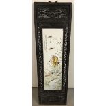 A large Chinese ceramic plaque mounted into an ornate wooden frame with pierced work detail.
