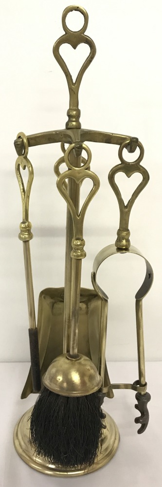 A vintage brass 5 piece companion set with heart shaped detail to handle.