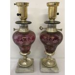 A pair of vintage lamps with etched cranberry coloured glass bowls, mounted onto marble plinths.