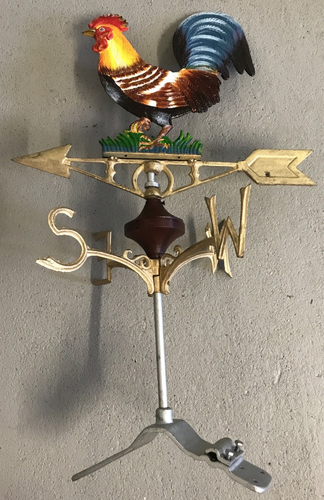 A modern painted cast metal weather vane with cockerel detail.