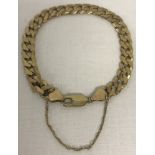 A 9ct gold curb chain bracelet with lobster clasp and safety chain.