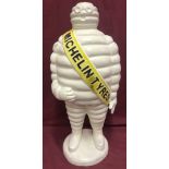 A very large cast iron Michelin Man figure, painted white.