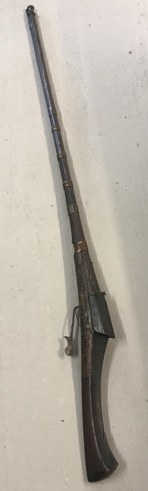 A 19th century matchlock Jezail gun with curved wooden stock.