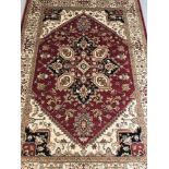 A Heriz pattern rug; red background with blue, beige and gold colouration.
