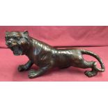 A hollow bronze figurine of a roaring tiger.