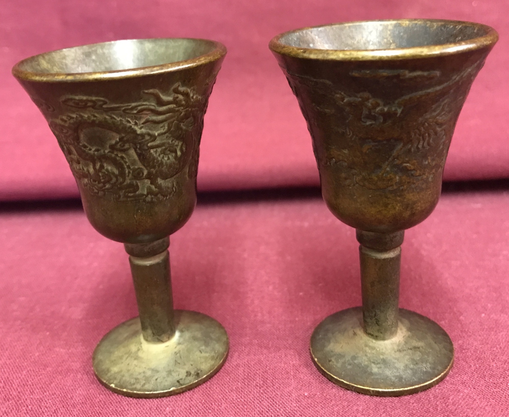 2 small Chinese bronze stemmed goblets with dragon design to outer bowl.