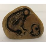 An Oriental carved soapstone seal with dragon and fish detail.