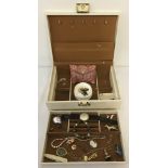 A vintage jewellery box containing a small amount of costume jewellery and other items.