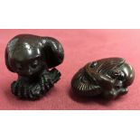 2 carved Japanese dark wood netsukes, both signed.